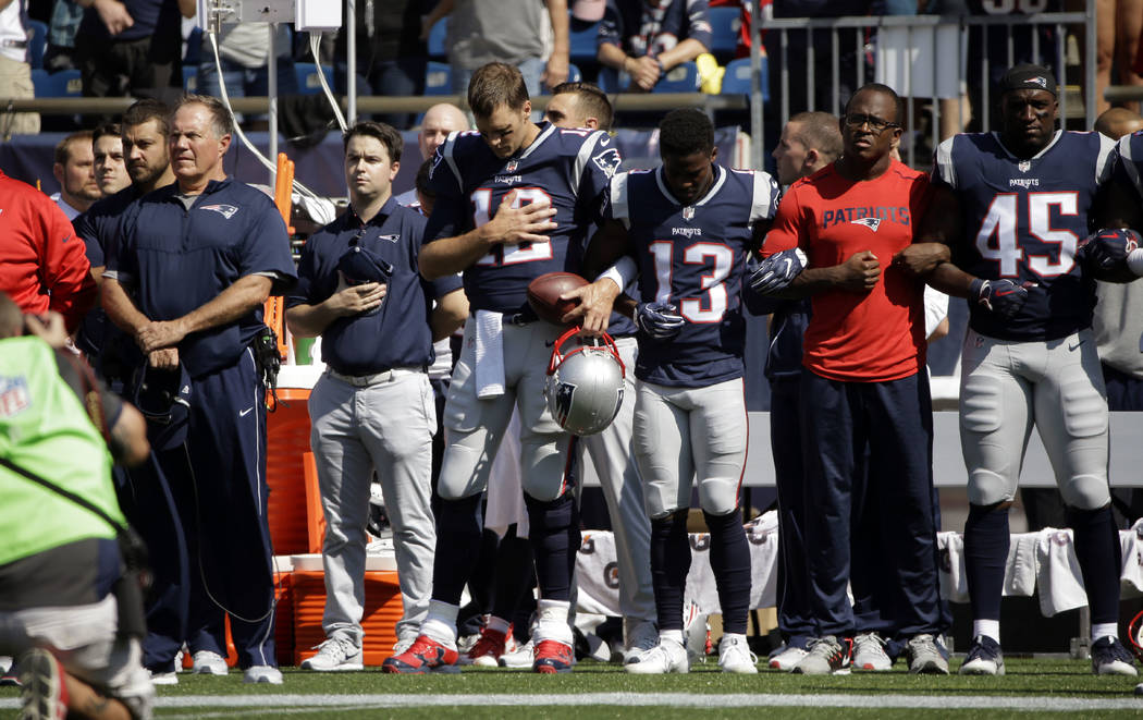 New England Patriots head coach Bill Belichick, left, and Tom Brady (12) Phillip Dorsett (13) Matthew Slater, second from right, and David Harris (45) stand during the national anthem before an NF ...