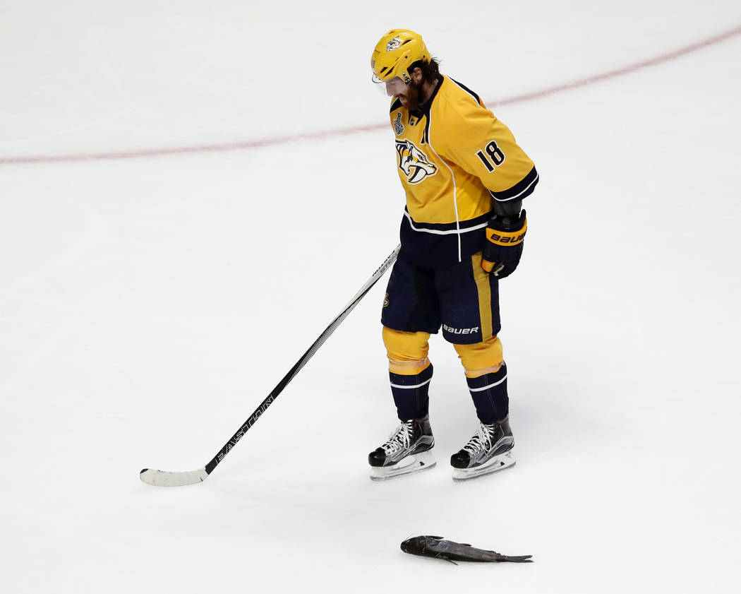 Nashville Predators' James Neal (18) skates by a catfish thrown onto the ice during the third period of Game 6 of the NHL hockey Stanley Cup Final against the Pittsburgh Penguins, Sunday, June 11, ...