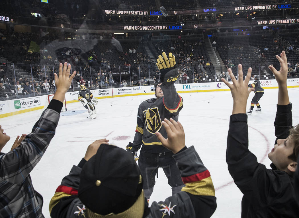 Zachary Gray, middle, and Zachary Zucker, right, reach for a puck during warmups during the Vegas Golden Knights first home preseason game with the Los Angeles Kings on Wednesday, Sept. 26, 2017,  ...