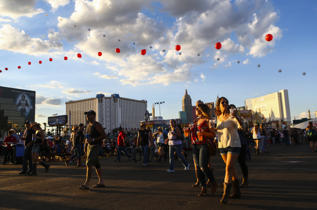 Attendees walk the festival grounds during the Route 91 Harvest country music festival at the MGM Resorts Village festival site in Las Vegas on Friday, Sept. 30, 2016. (Chase Stevens/Las Vegas Rev ...