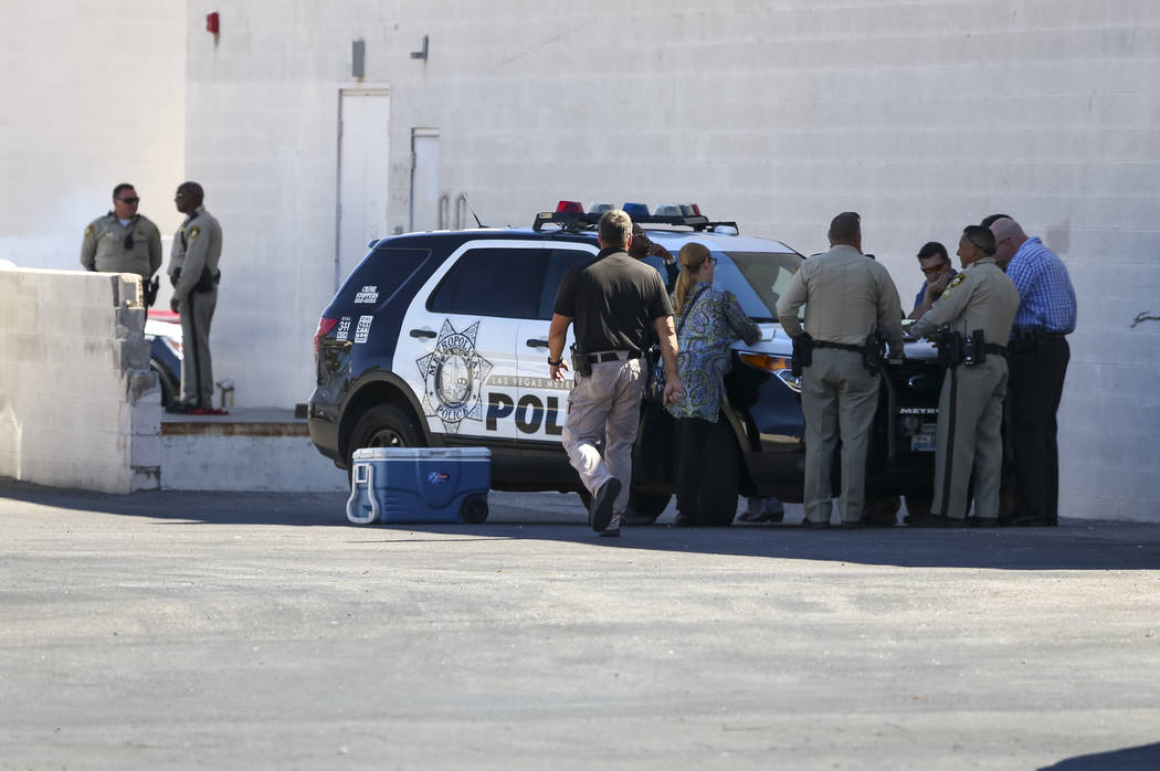 Metropolitan Police and detectives meet at the perimeter of a scene as they investigate an officer-involved shooting that occurred in a strip mall near Jones Boulevard and U.S. Highway 95 on Thurs ...