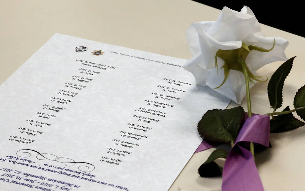 A rose is placed next to a list of names of domestic violence victims at the Metropolitan Police Department headquarters in Las Vegas on Wednesday, Sept. 27, 2017, during the annual ceremony to re ...
