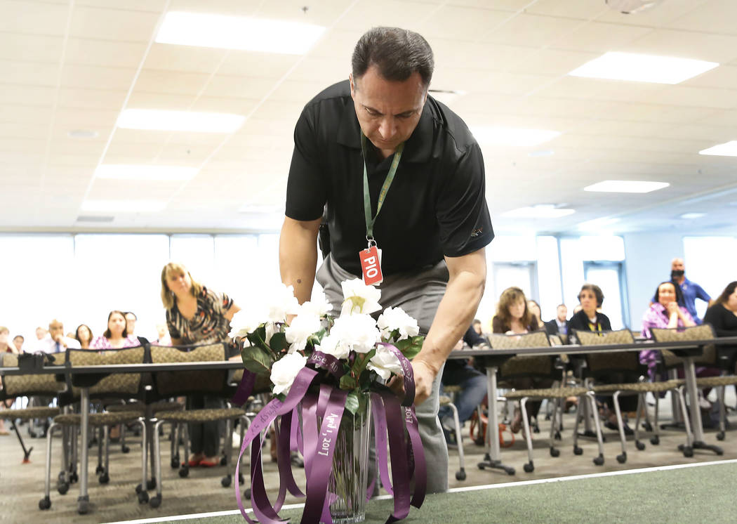 Jay Rivera of the Metropolitan Police Department places a rose at Metro's headquarters on Wednesday, Sept. 27, 2017, during the annual ceremony to remember victims of domestic violence. Bizuayehu  ...