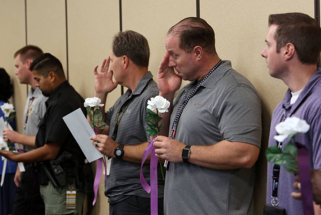 Roger Price, second from right, and Glenn Brook, third from right, both from the Metropolitan Police Department, attend the annual ceremony to remember victims of domestic violence at Metro's head ...