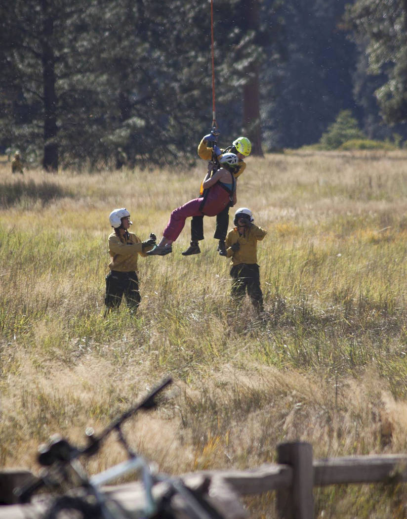 In this Wednesday, Sept. 27, 2017, photo provided by Dakota Snider, photographer and Yosemite resident, a woman is lowered by a helicopter after being lifted off El Capitan following a major rock ...