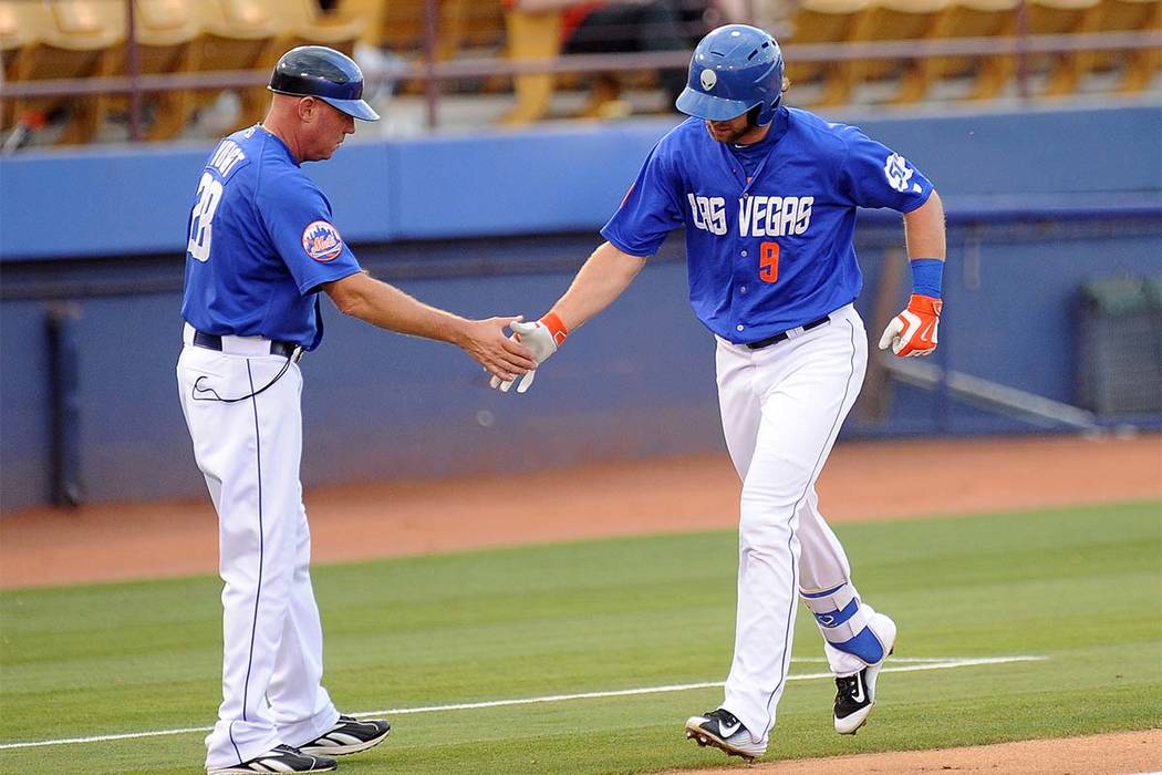 Las Vegas 51s base runner Kirk Niuwenhuis (9) high fives third base coach Jack Voigt after hitting a three-run home run against the Sacramento River Cats in the first inning of a Triple-A minor le ...