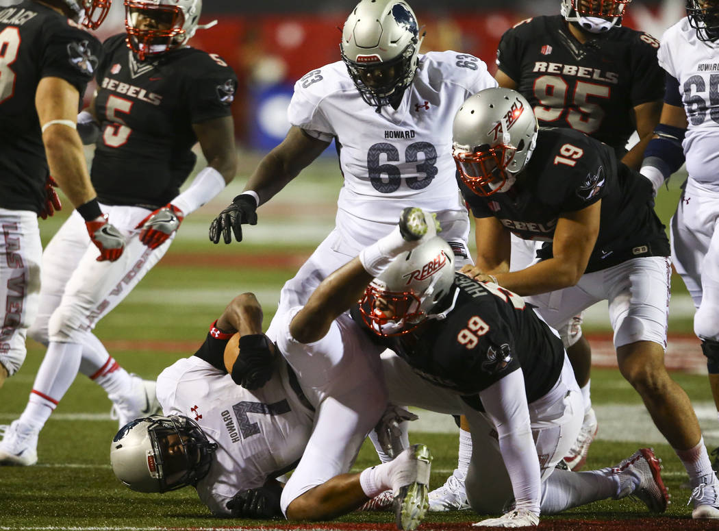 UNLV defensive lineman Mike Hughes Jr. (99) takes down Howard running back Anthony Philyaw (7) during a football game at Sam Boyd Stadium in Las Vegas on Saturday, Sept. 2, 2017. Chase Stevens Las ...
