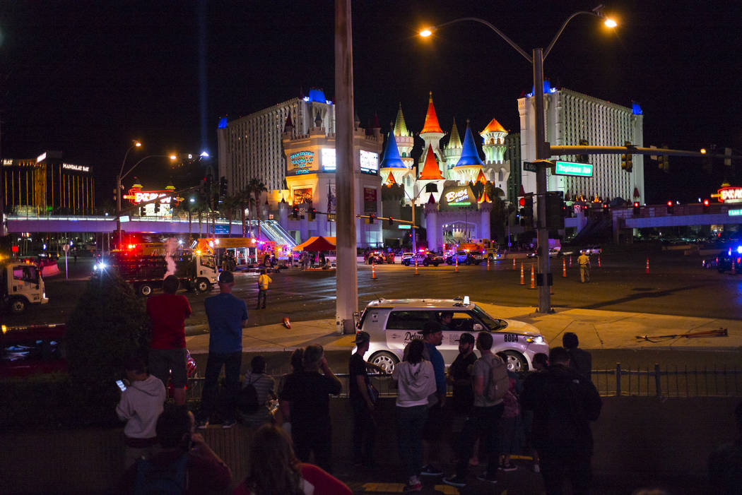 Pedestrians look on as Las Vegas police respond during an active shooter situation on the Las Vegas Strip near Tropicana Avenue in Las Vegas on Sunday, Oct. 1, 2017. Chase Stevens Las Vegas Review ...