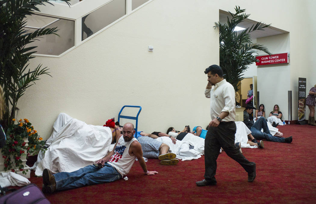 People relax in a convention center area during lockdown at the Tropicana Las Vegas following an active shooter situation that left 50 dead and over 200 injured on the Las Vegas Strip during the e ...