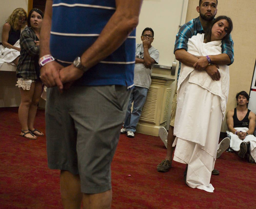 People wait out a lockdown in a convention center area at the Tropicana Las Vegas following an active shooter situation that left 50 dead and over 200 injured on the Las Vegas Strip during the ear ...