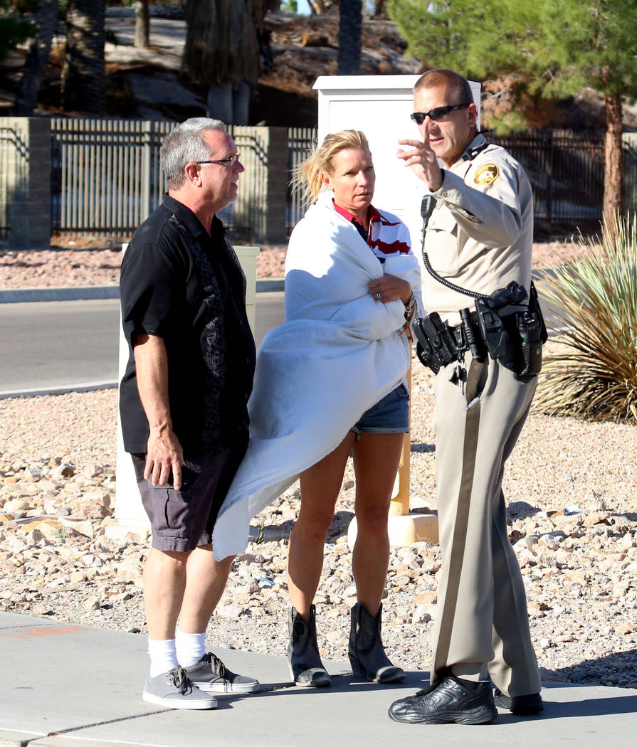 Kathy Boggio-Mocnik and her husband Gary, both of Aliso Viejo, Calif., talk to a Metro police officer as they return to Mandalay Bay hotel-casino on Monday, Oct. 2, 2017 where at least 58 people w ...
