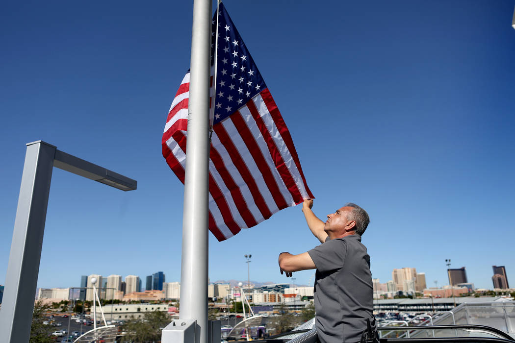 Moises Flores with UNLV facility operations raises a new American flag to half-staff at Thomas & Mack Center in Las Vegas, Monday, Oct. 2, 2017, after a gunman opened fire on the Strip Sunday  ...