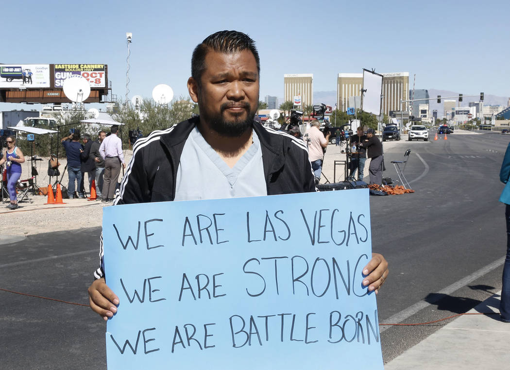 Jon Dimaya, nurse at Sunrise Hospital, holds a sign that reads &quot;We are Las Vegas, We are Strong, We are Battle Born'' on Las Vegas Boulevard near Mandalay Bay hotel-casino on Monday, Oct. ...