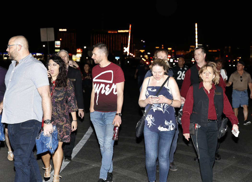People who have been evacuated from Mandalay Bay hotel-casino walk on Las Vegas Boulevard as Las Vegas police respond during an active shooter situation on the Strip on Sunday, Oct. 2, 2017, in La ...