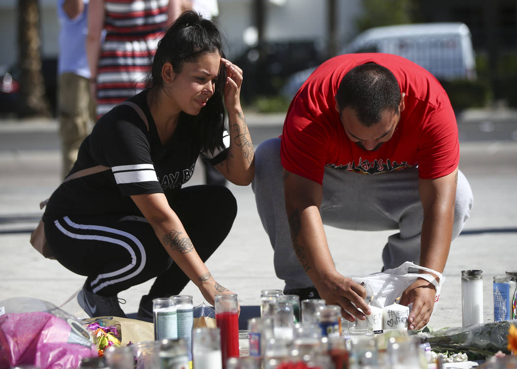 Las Vegas residents Elba Armendariz, left and David Robles leave candles at a memorial at Las Vegas Boulevard and Sahara Avenue in Las Vegas during the early hours of Tuesday, Oct. 3, 2017. A gunm ...