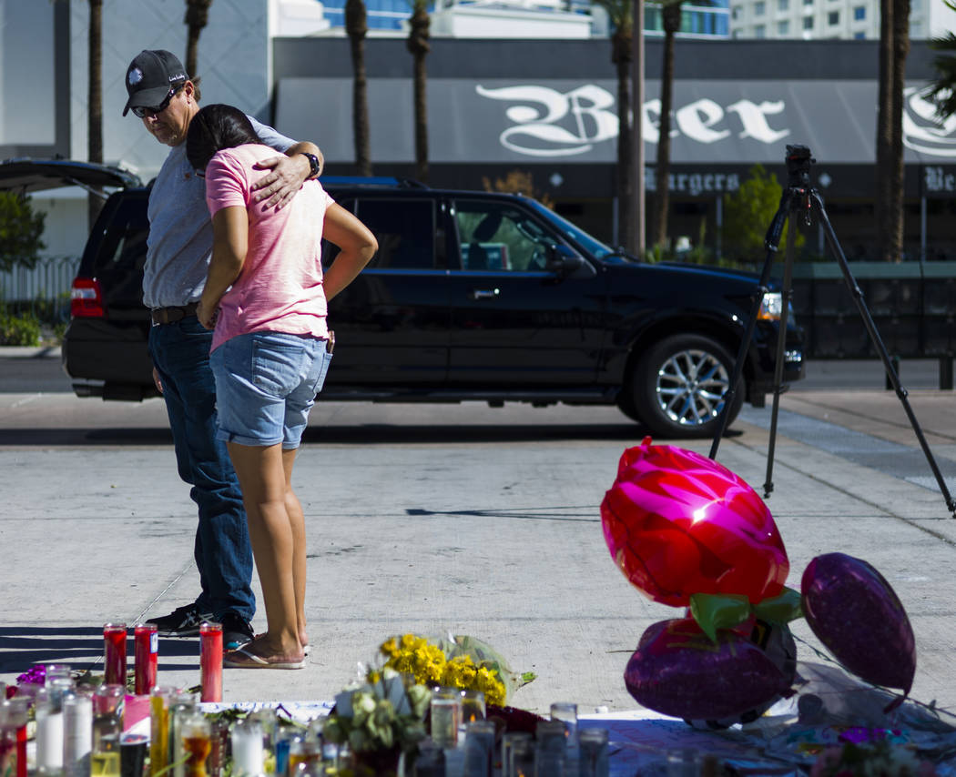 Mike and Jessica Yerkey of Ramona, Calif. pause at a memorial at Las Vegas Boulevard and Sahara Avenue in Las Vegas during the early hours of Tuesday, Oct. 3, 2017. A gunman opened fire on attende ...