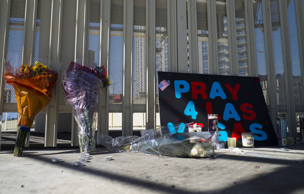 Signs, flowers and candles are some of many items left at a memorial at Las Vegas Boulevard and Sahara Avenue in Las Vegas during the early hours of Tuesday, Oct. 3, 2017. A gunman opened fire on  ...