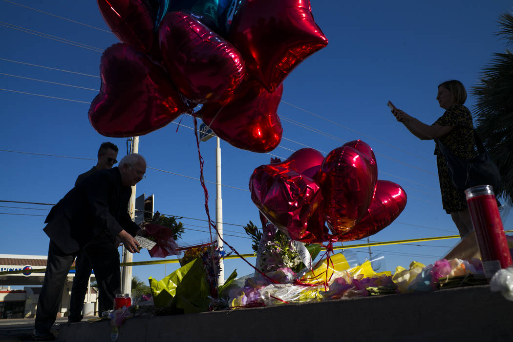 United States Conference of Mayors CEO and Executive Director Tom Cochran, left, places roses by a memorial at Las Vegas Boulevard and Reno Avenue outside of the Luxor, near the Route 91 music fes ...