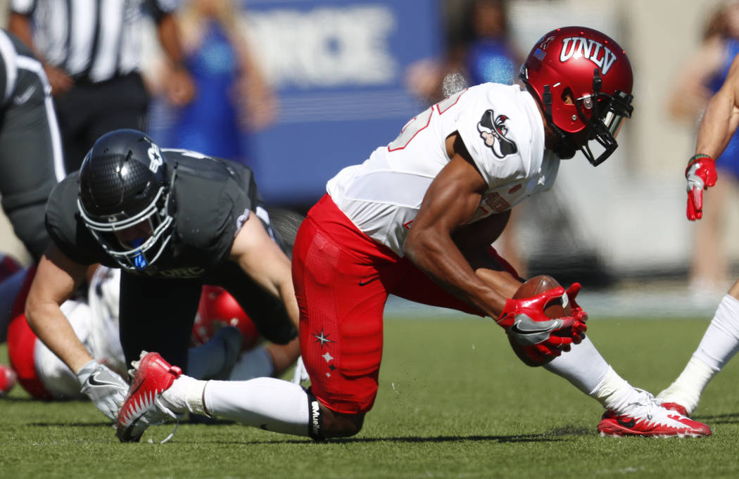UNLV cornerback Jocquez Khalili, front, picks up a fumble from Air Force running back Nolan Eriksen in the second half of an NCAA college football game, Saturday, Oct. 14, 2017, at Air Force Acade ...