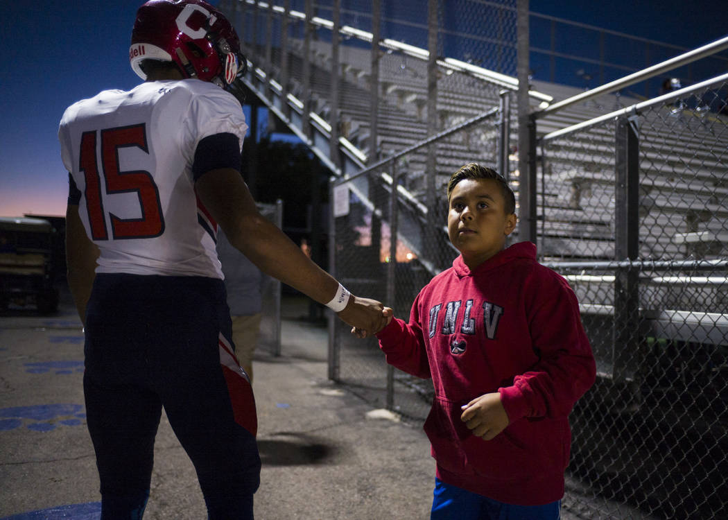 Coronado's Ayzayah Hartfield (15), son of fallen Las Vegas police officer Charleston Hartfield, gets a high-five from a young fan before a football game at Basic High School in Henderson on Friday ...