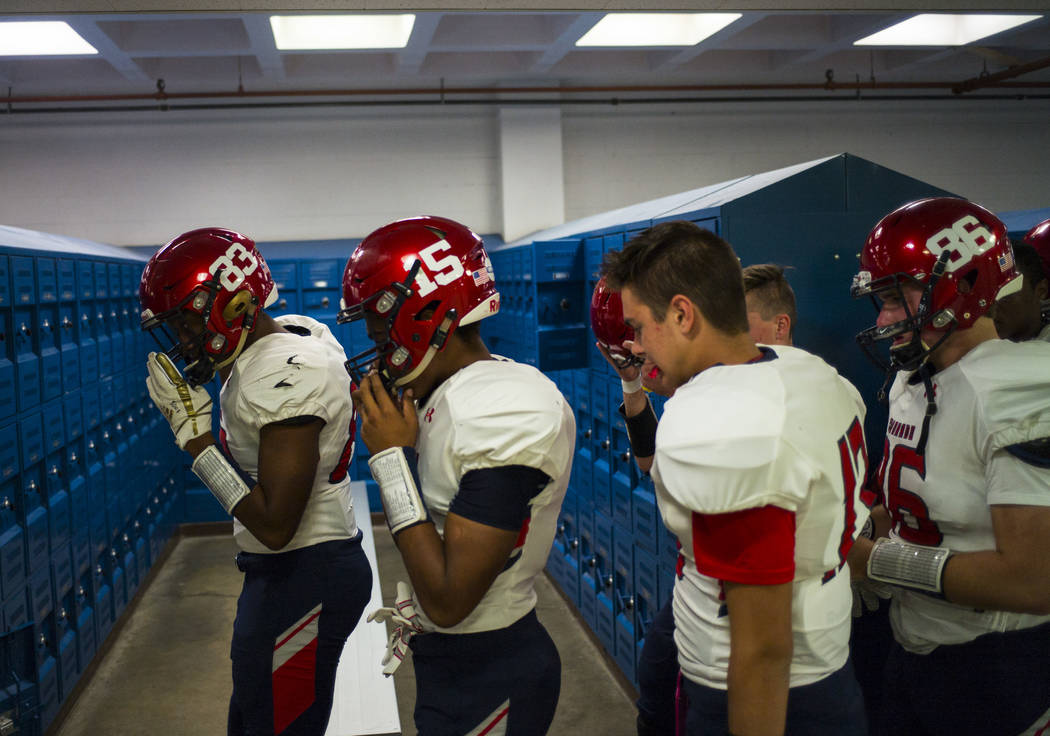 Coronado's Ayzayah Hartfield (15), son of fallen Las Vegas police officer Charleston Hartfield, huddles with teammates for a prayer in the locker room before a football game at Basic High School i ...