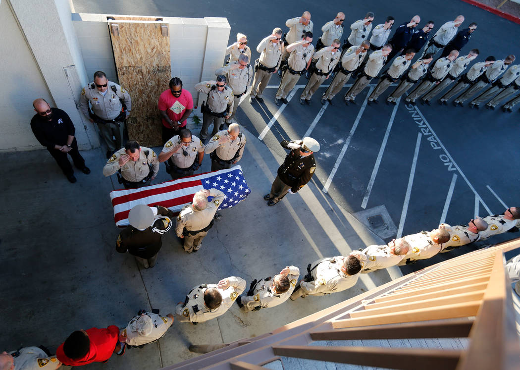 Metropolitan Police Department officers salute the casket of officer Charleston Hartfield on Tuesday, Oct. 3, 2017, as his it arrives at Palm Downtown Mortuary and Cemetery in Las Vegas. Hartfield ...