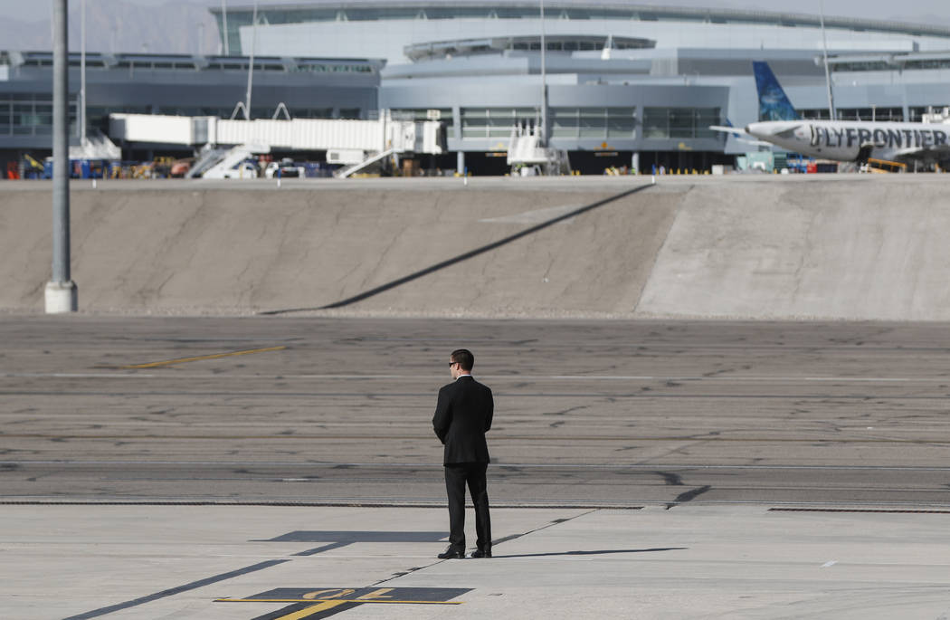 A Secret Service officer waits for the arrival of President Donald Trump at McCarran International Airport in Las Vegas on Wednesday, Oct. 4, 2017. A gunman opened fire on attendees of a music fes ...