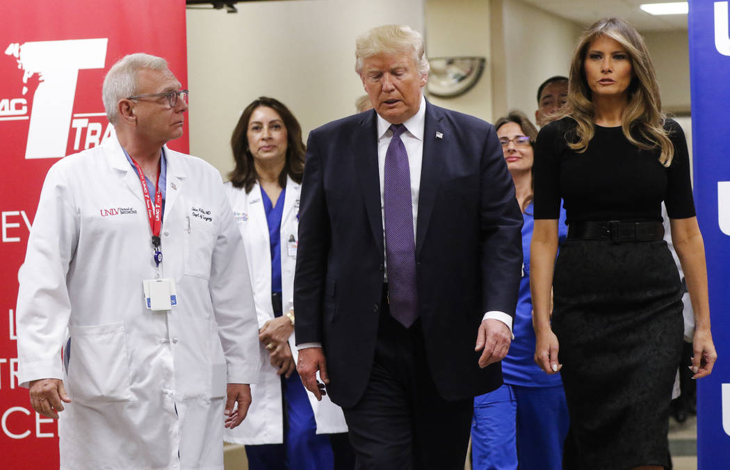President Donald Trump and first lady Melania Trump walk alongside physician John Fildes, left, after visiting victims at University Medical Center in Las Vegas on Wednesday, Oct. 4, 2017. A gunma ...