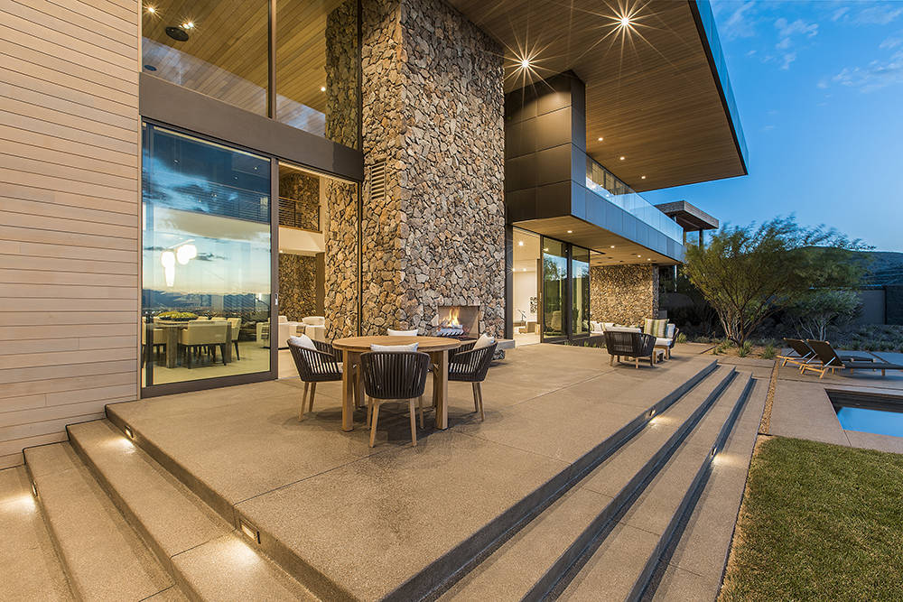 A massive double-sided fireplace is featured in the living area and outdoor patio. (Ascaya)