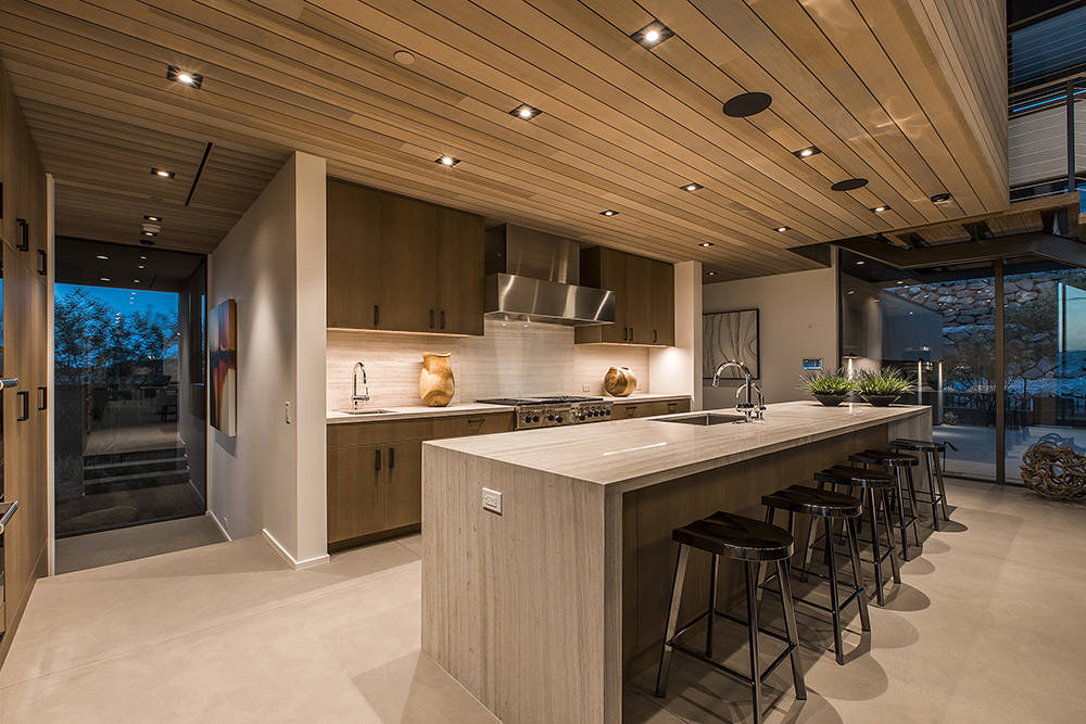 The kitchen's large island is topped with white-striped quartzite stone with a natural waterfall design. (Ascaya)