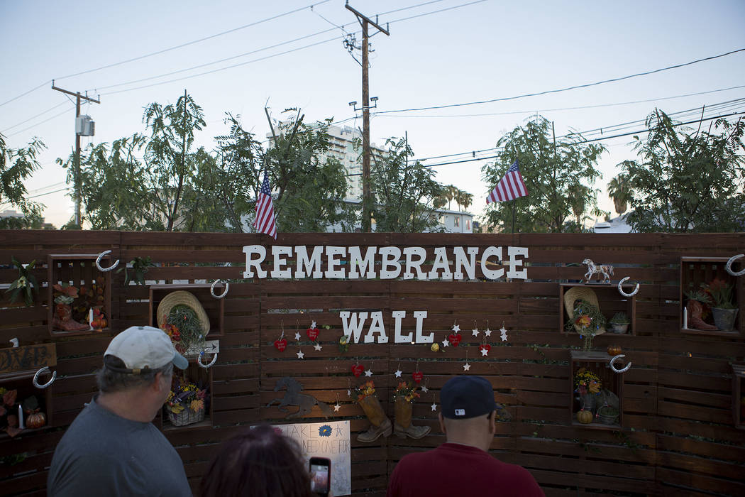 Attendees walk past the &quot;Remembrance Wall&quot; at the Community Healing Garden in Las Vegas, Friday, Oct. 6, 2017. The city of Las Vegas dedicated the new healing garden to victims o ...