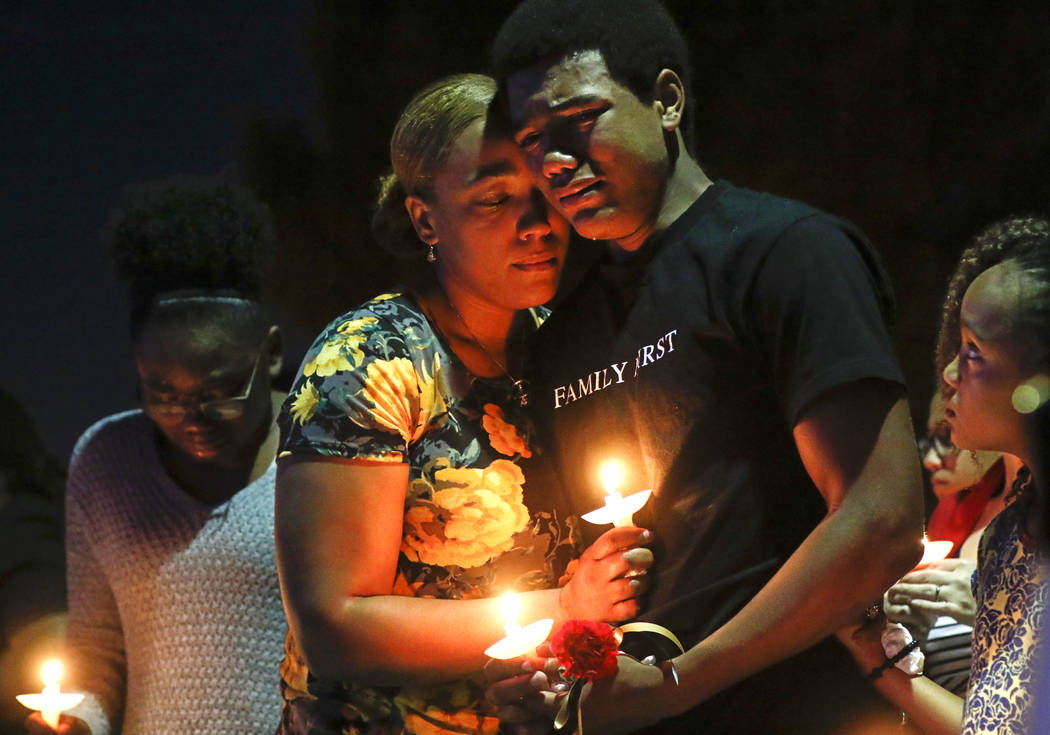 Veronica Hartfield, left, and son Ayzayah, wife and son of fallen officer Charleston Hartfield, during a candlelight vigil for in his memory at Police Memorial Park in Las Vegas on Thursday, Oct.  ...
