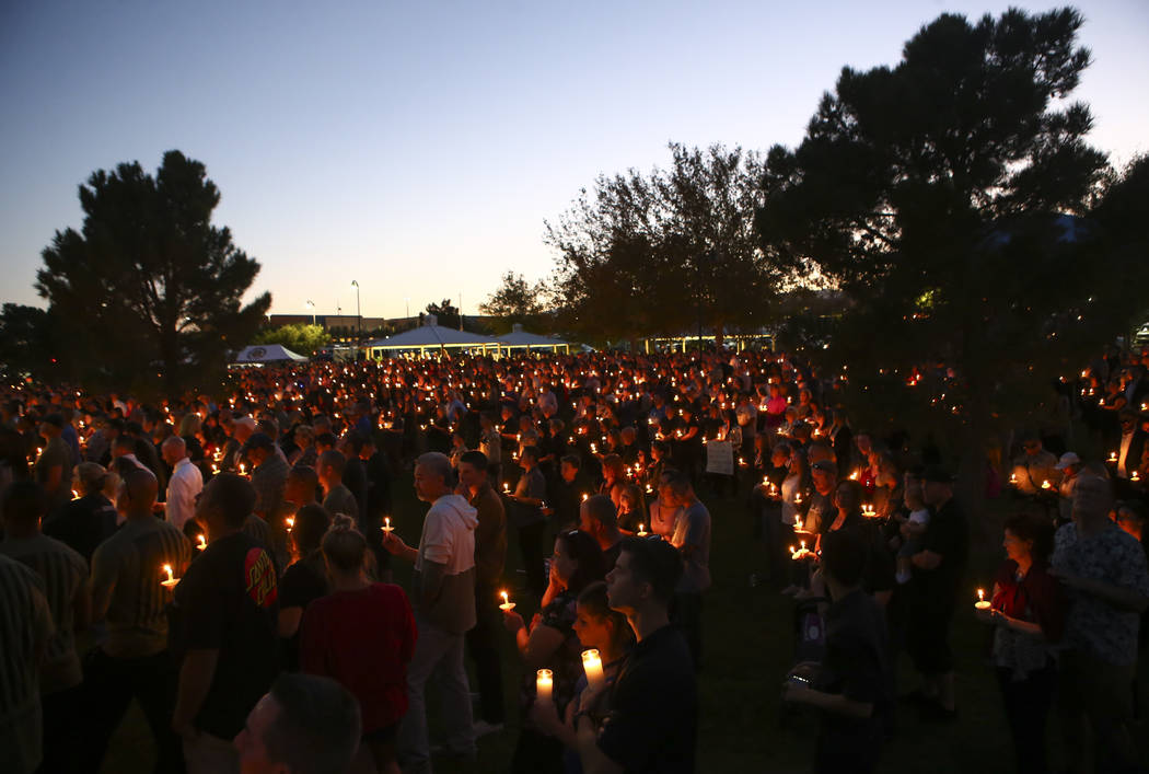 Attendees during a candlelight vigil for Las Vegas police officer Charleston Hartfield, who was killed while off-duty in Sunday's mass shooting, at Police Memorial Park in Las Vegas on Thursday, O ...