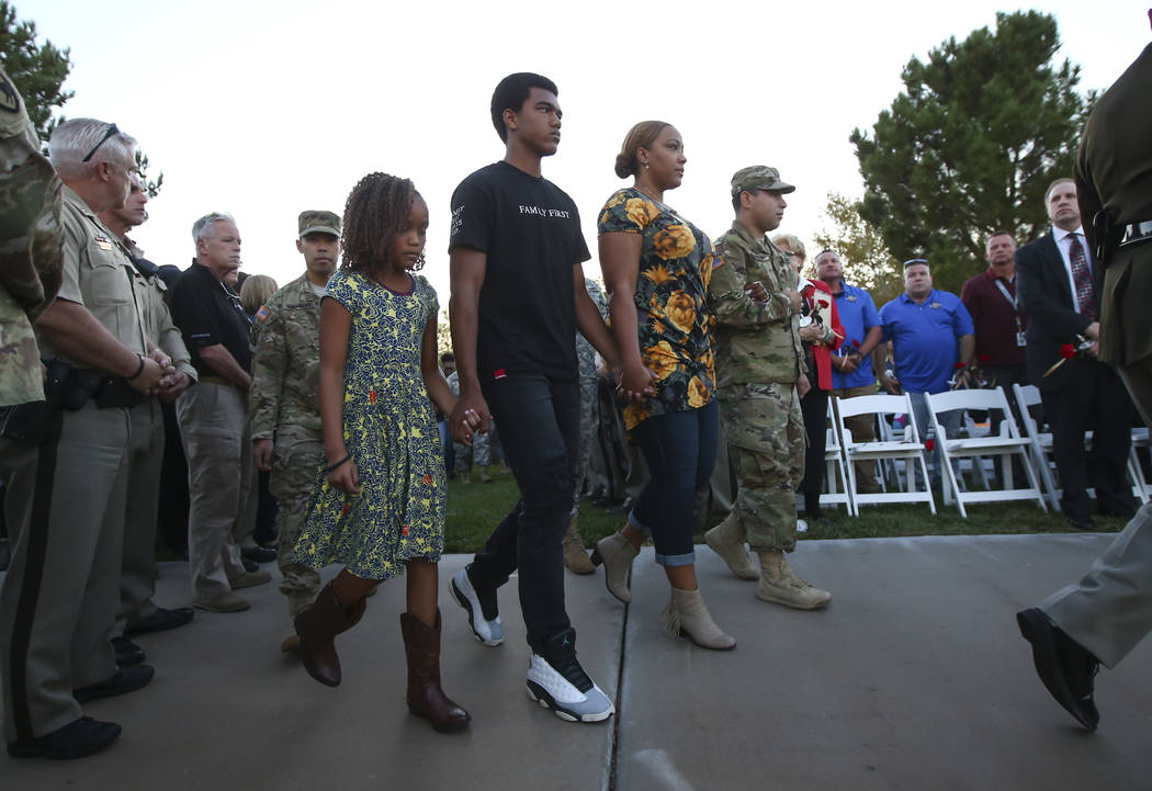 Family of fallen Las Vegas police officer Charleston Hartfield, from left, daughter Savannah, son Ayzayah, and wife Veronica, arrive during a candlelight vigil in Hartfield's memory at Police Memo ...