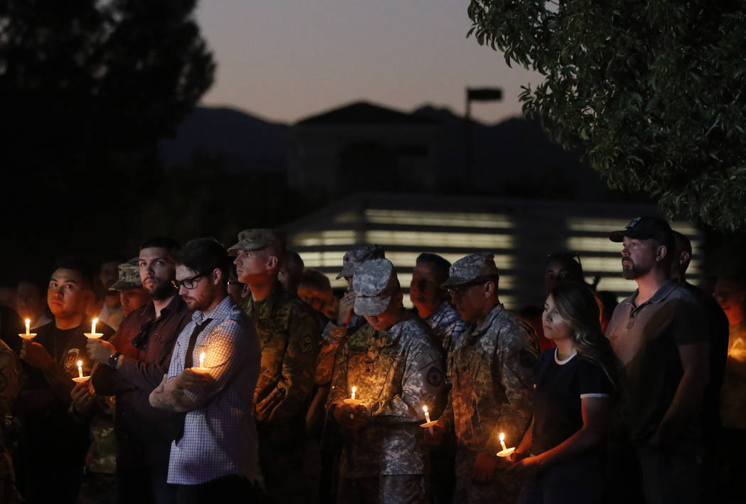 People attend a candlelight vigil for Las Vegas police officer Charleston Hartfield, who was killed while off-duty in Sunday's mass shooting, at Police Memorial Park in Las Vegas on Thursday, Oct. ...