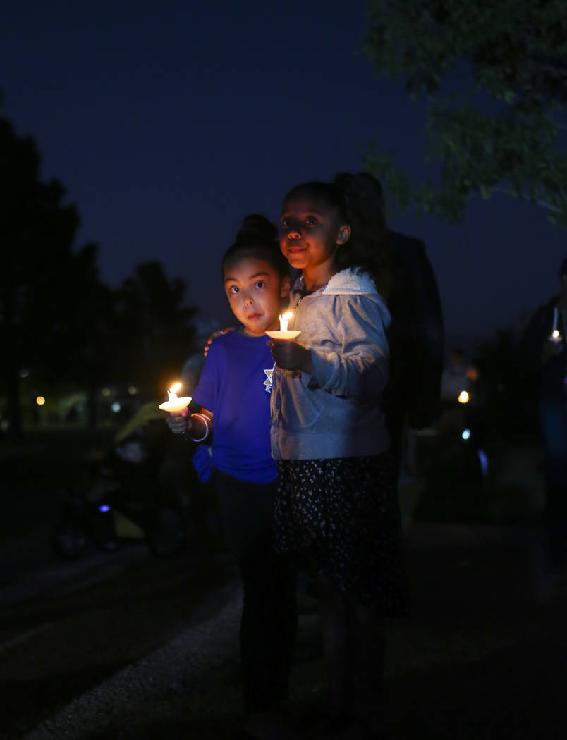Seven-year-olds Abigail, left, and Naomee during a candlelight vigil for Las Vegas police officer Charleston Hartfield, who was killed while off-duty in Sunday's mass shooting, at Police Memorial  ...