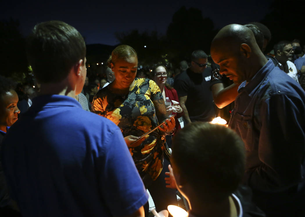 People visit with Veronica Hartfield, center, wife of fallen officer Charleston Hartfield, after a candlelight vigil for in his memory at Police Memorial Park in Las Vegas on Thursday, Oct. 5, 201 ...