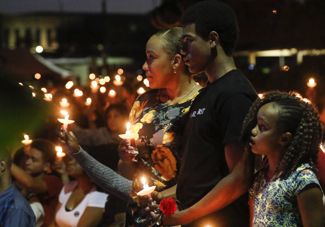 Veronica Hartfield, from left, with children Ayzayah, and Savanna,h family of fallen officer Charleston Hartfield, during a candlelight vigil for in his memory at Police Memorial Park in Las Vegas ...