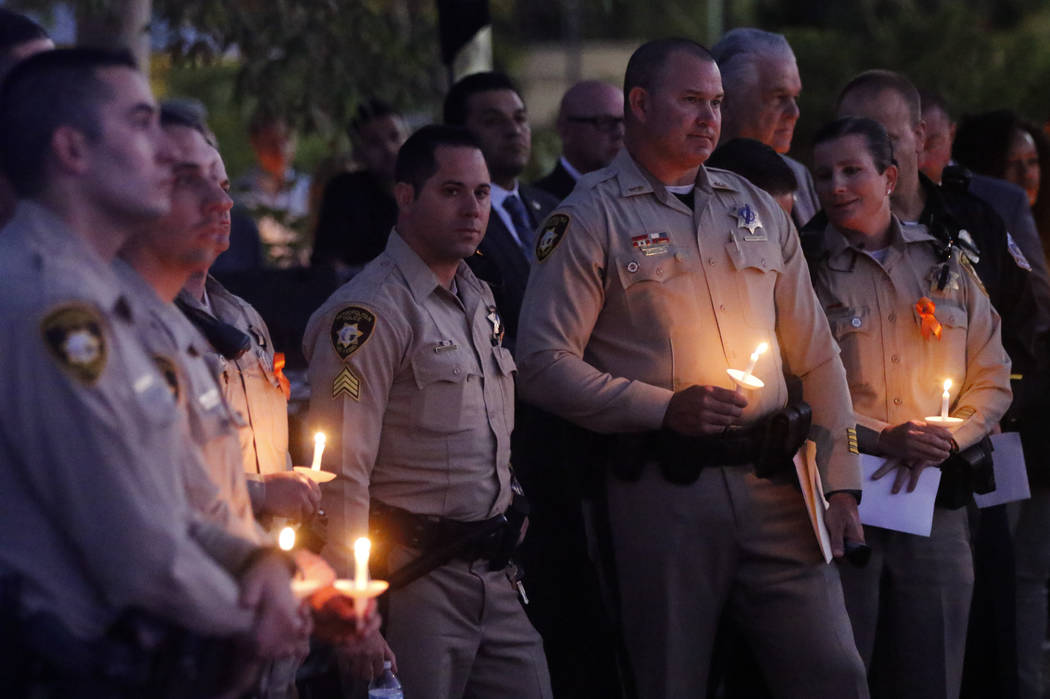 Las Vegas police officers during a candlelight vigil for Las Vegas police officer Charleston Hartfield, who was killed while off-duty in Sunday's mass shooting, at Police Memorial Park in Las Vega ...