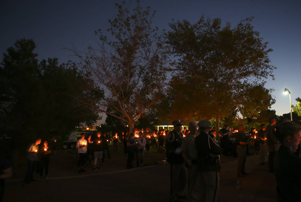 People attend a candlelight vigil for Las Vegas police officer Charleston Hartfield, who was killed while off-duty in Sunday's mass shooting, at Police Memorial Park in Las Vegas on Thursday, Oct. ...