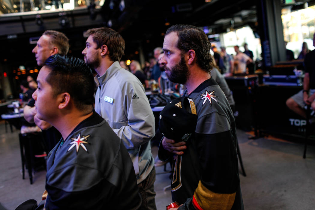 T.J. O'Donnell of Las Vegas, 30, places his hand over his heart during the national anthem at a watch party for the Vegas Golden Knights season opener against the Dallas Stars at Topgolf in Las Ve ...