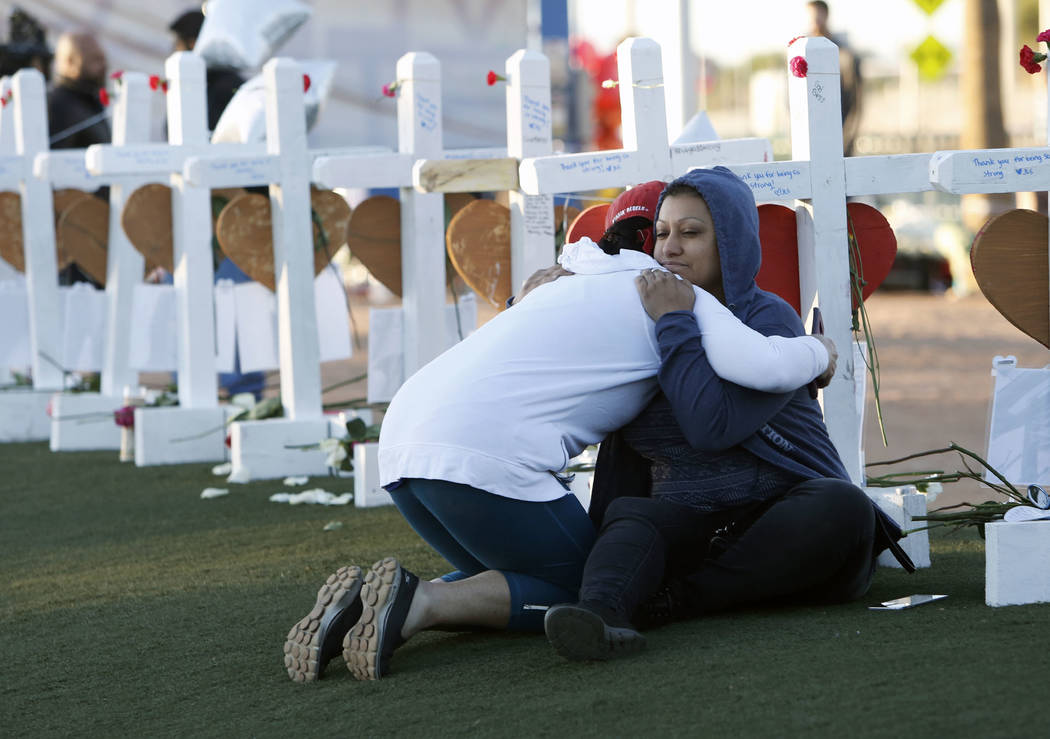 Shelley Boyle, left, and Cece Navarrette comfort each other on the Las Vegas Strip where fifty-eight white crosses stand to honor the victims of Sunday's mass shooting on Friday, Oct. 6, 2017, in ...