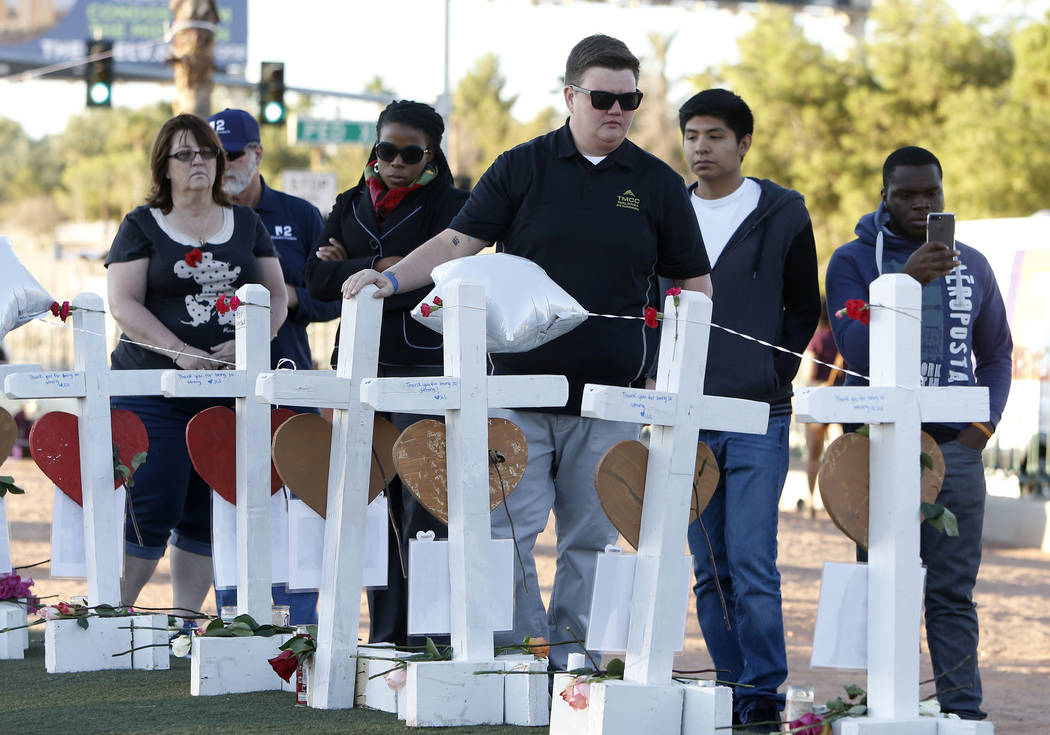 People gather on the Las Vegas Strip where fifty-eight white crosses stand to honor the victims of Sunday's mass shooting on Friday, Oct. 6, 2017, in Las Vegas. Bizuayehu Tesfaye Las Vegas Review- ...