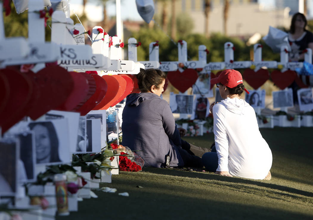 Cece Navarrette, left, and Shelley Boyle share a moment on the Las Vegas Strip where fifty-eight white crosses stand to honor the victims of Sunday's mass shooting on Friday, Oct. 6, 2017, in Las ...