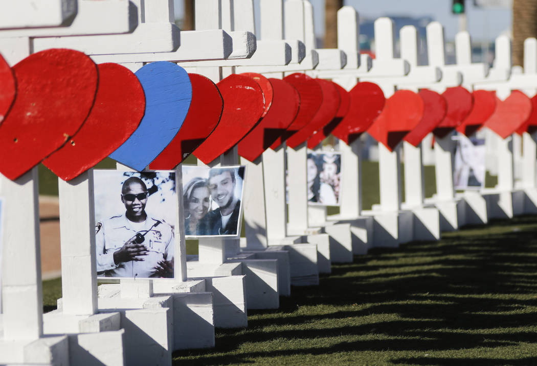 Photos of victims of Sunday's mass shooting on crosses left in their memory near the "Welcome to Fabulous Las Vegas" sign in Las Vegas on Thursday, Oct. 5, 2017. Chase Stevens La ...