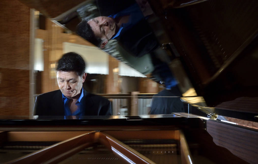 Keith Thompson, “Jersey Boys” conductor and co-composer of “Idaho! The Comedy Musical” is reflected in the lid of a piano at the Smith Center for the Performing Arts at ...