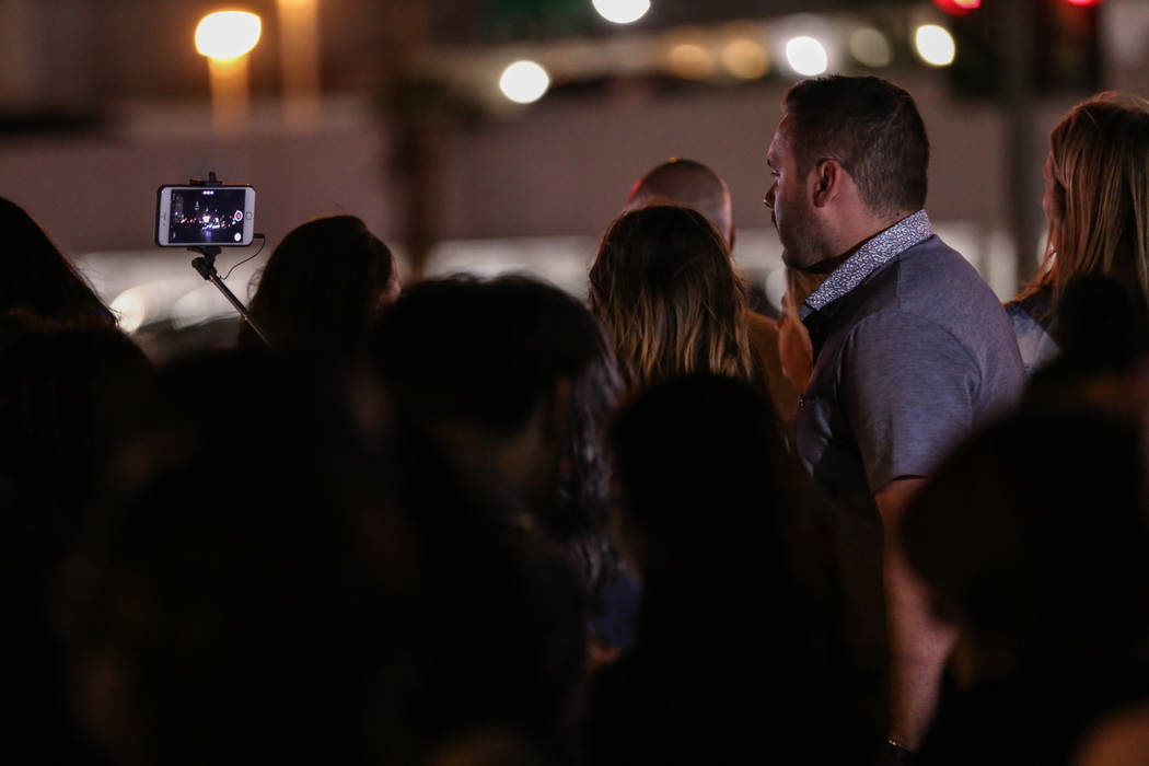 People gather as some lights turned off at 10:05 p.m. for 11 minutes marking exactly one week after the mass shooting at the Route 91 Harvest Festival in Las Vegas, Sunday, Oct. 8, 2017. Joel Ange ...