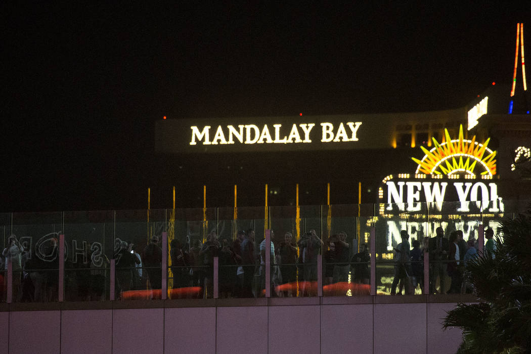 Pedestrians stand on top of a walking bridge as marquees on the Strip go dark one week after the Oct. 1, 2017 mass shooting in Las Vegas, Sunday, Oct. 8, 2017. Bridget Bennett Las Vegas Review-Jou ...
