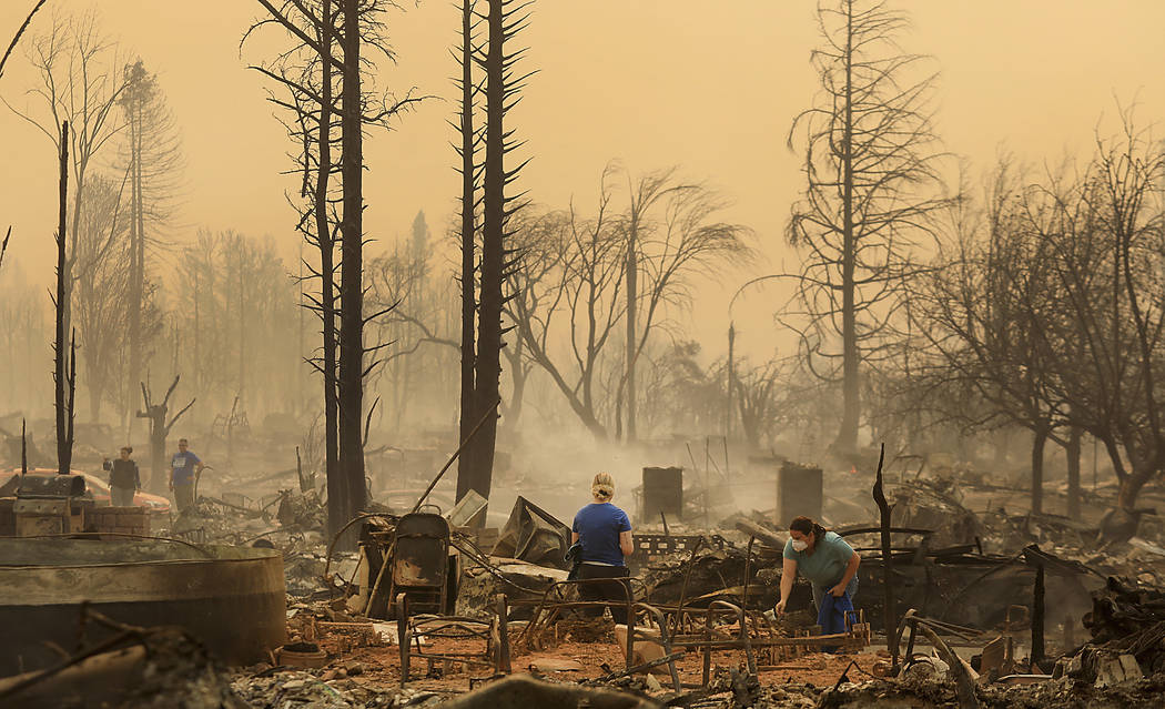 Residents of the Coffey Park neighborhood sift through a relatives home that was torched, Monday, Oct. 9, 2017 in Santa Rosa. More than a dozen wildfires whipped by powerful winds been burning tho ...