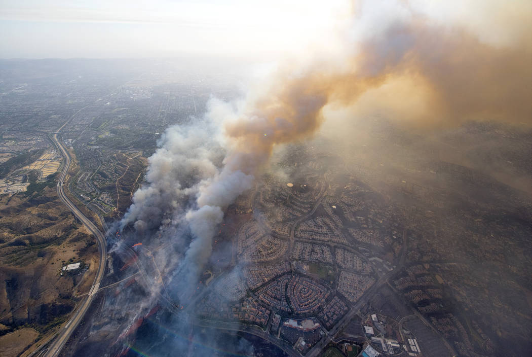 A wildfire moves closer to North Tustin homes along the 261 freeway in Tustin, Calif., Monday, Oct. 9, 2017. Deadly wildfires whipped by powerful winds swept through California wine country Monday ...